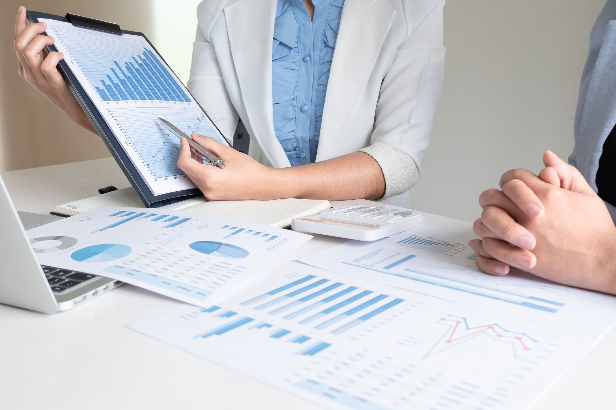 Two business leader women discussing the charts and graphs showing the results